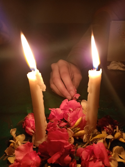 Romantic candle light and flowers with girls hand 