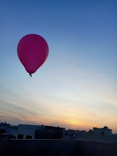 Balloon in the air with sunset in background
