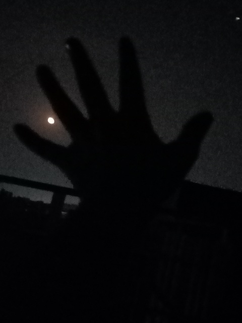Sky moon between fingers