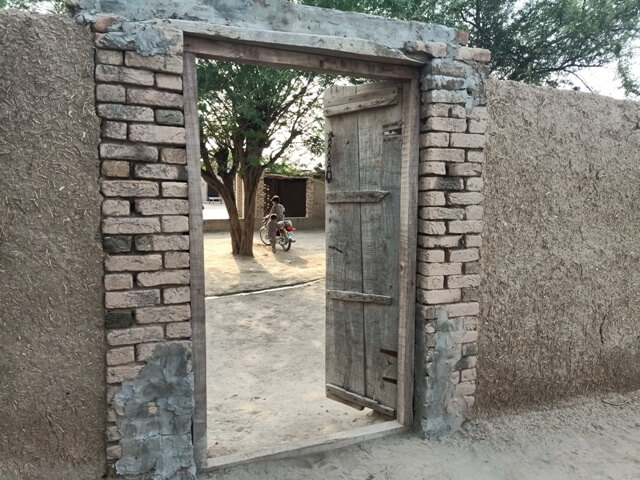An open door between a mud wall