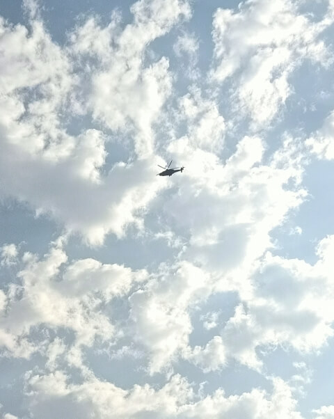 Cloudy sky with a tiny helicopter 