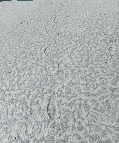 Faded foot impressions on sand