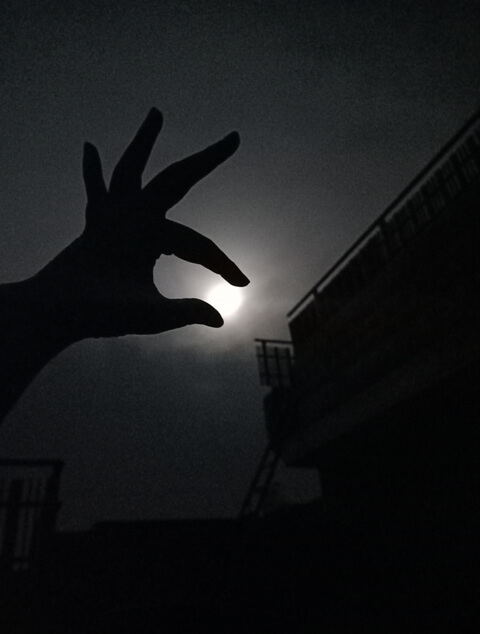 A girl catching moon with hand