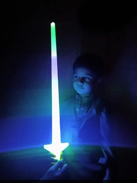 A small passionate boy with his neon sword