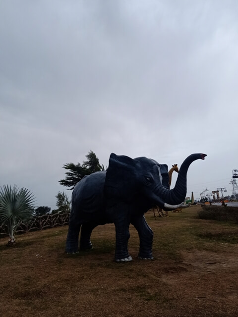 Elephant model in park with cloudy sky