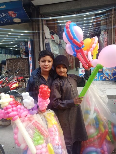 Children selling balloons in streets 