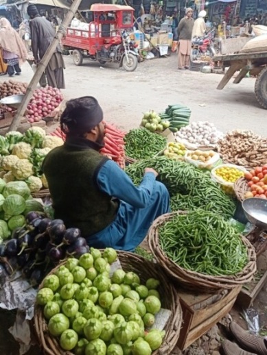 A man with his colorful vegetable stall 