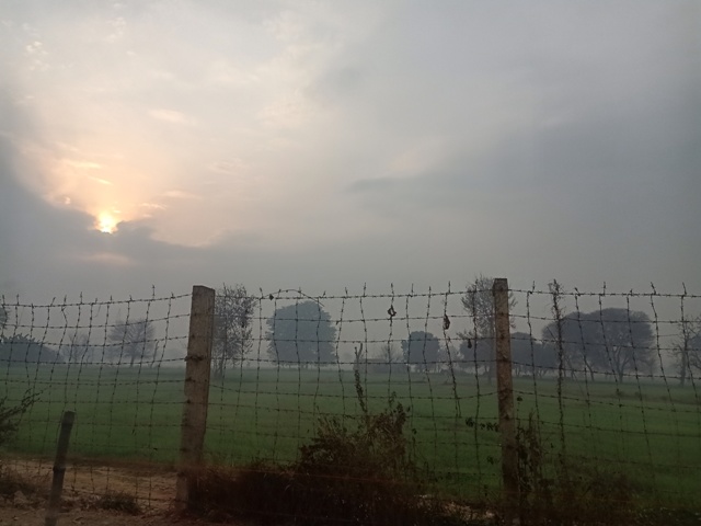 Cloudy sky with sun and a landscape 