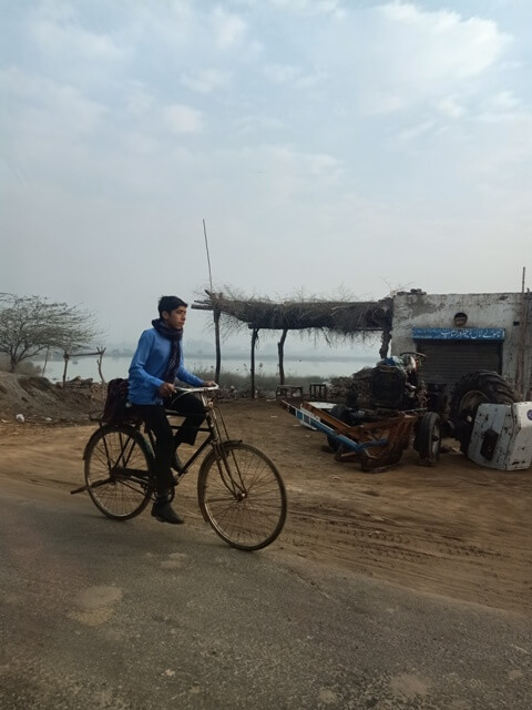 A countryside boy on the way to his school on his bicycle 