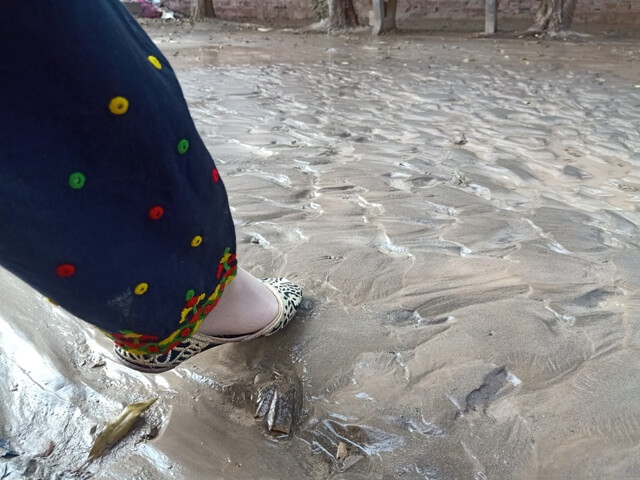 A girls foot on the surface of a river bed 